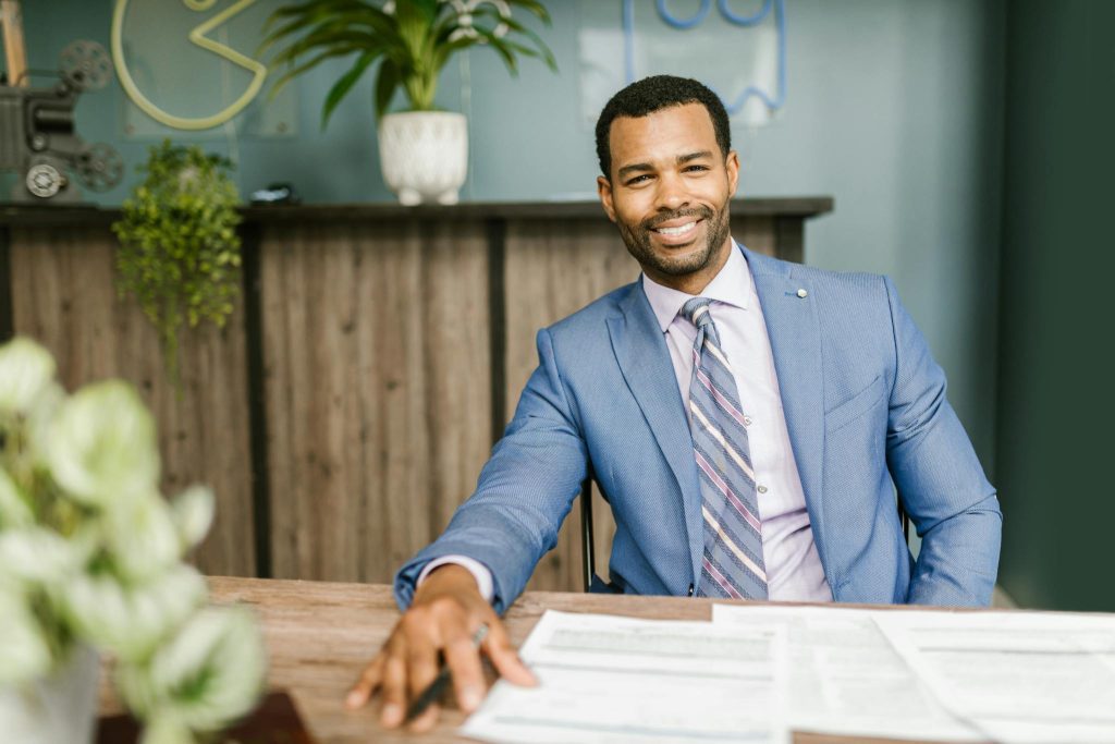 Confident businessman in corporate attire smiling because of good article writing services